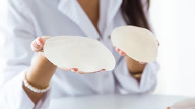 Eine Frau hält Implantate in der Hand