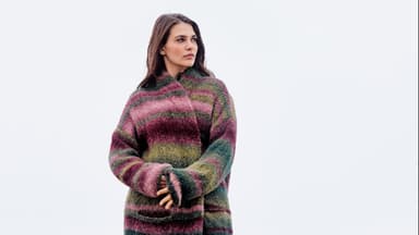 Model in gestreiftem Strickmantel von Lana Grossa