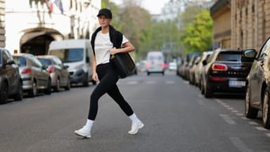 Diane Batoukina trägt schwarze Sport-Leggings weißes T-Shirt schwarze Cap und schwarze Tasche