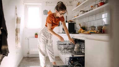 Eine Frau räumt die Spülmaschine ein