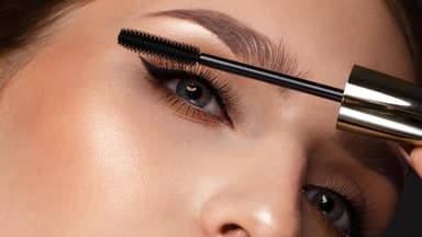 Schöne Frau trägt Mascara auf