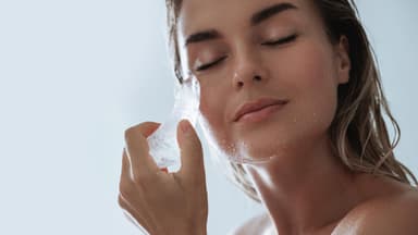 schöne Frau mit Eis am Gesicht