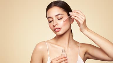 Frau vor allem Hintergrund trägt Serum auf