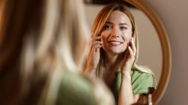 Frau strahlt sich im Spiegel an