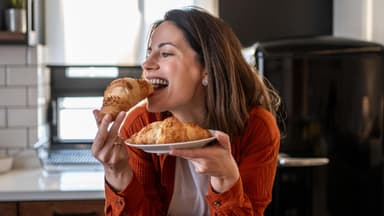 Frau beisst in Croissant