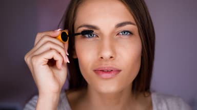 Frau im Close-up tuscht wimpern