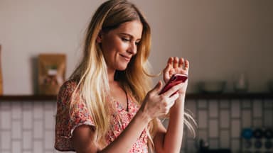 Frau beugt sich für Smartphone nach vorn