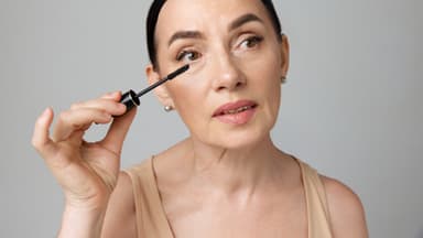 Frau trägt mit dem Mascara-Trick für Schlupflider Wimperntusche auf