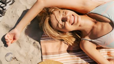 Frau mit Sonnencreme gegen Pickel im Gesicht