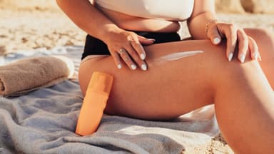 Frau verwendet Sonnencreme mit Bräunungsbeschleuniger