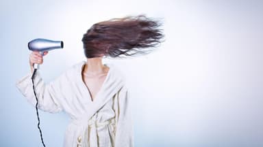 Eine Frau föhnt ihre Haare