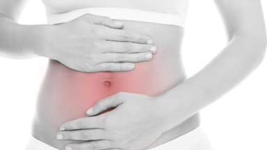 Frau hält sich wegen Schmerzen den Bauch - Tipps bei Unverträglichkeit 