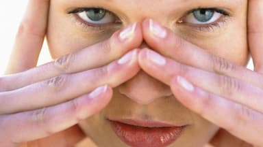 Frau umfasst mit den Händen Ihre Augenpartie - In unseren Tipps erfahren Sie, wie Sie den Falten vorbeugen können und was bei bestehenden Fältchen hilft