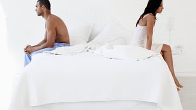Pärchen sitzt auf Bett