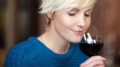 Frau trinkt Rotwein – enthaltenes Resveratrol hilft beim Abnehmen