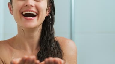 Lachende Frau in der Dusche - Tipps für eine bessere Durchblutung 