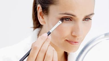 Frau schminkt sich die grünen Augen - Das perfekte Make-Up für grüne Augen 
