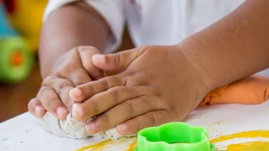 Kinderhände beim Selbermachen von Knete