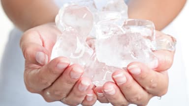 Frau hält Eiswürfel