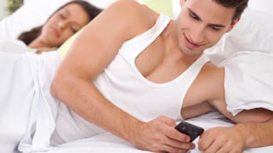 Mann und Frau liegen zusammen im Bett - Betrügt er sie?