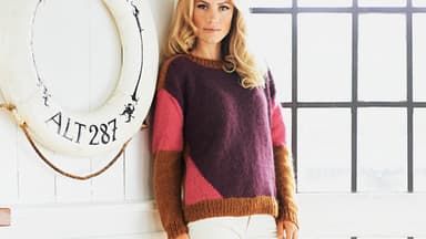 Blonde Frau in Strickpullover mit Farbflächen und vorverlegten Schultern