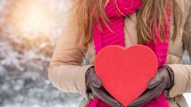 Frau hält Geschenk für Mann zum Valentinstag - Tipps für das richtige Valentinstagsgeschenk für Männer 