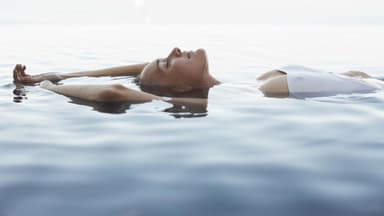Frau liegt im Meer 