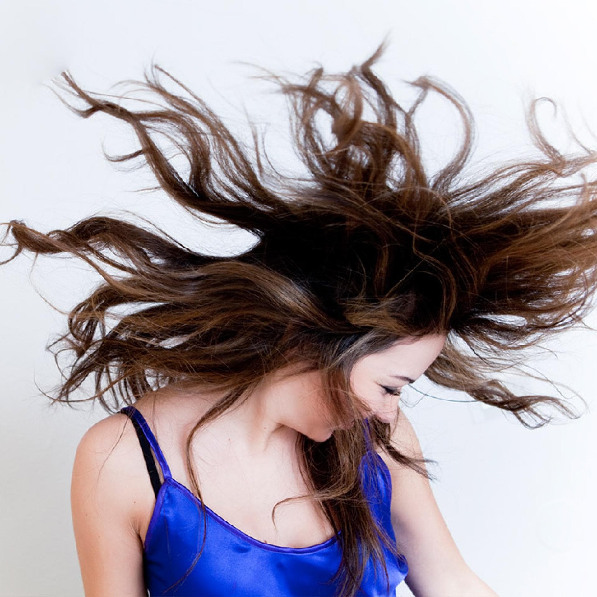 Frau wirft Haare hoch - So pflegen Sie Ihre Haare richtig 