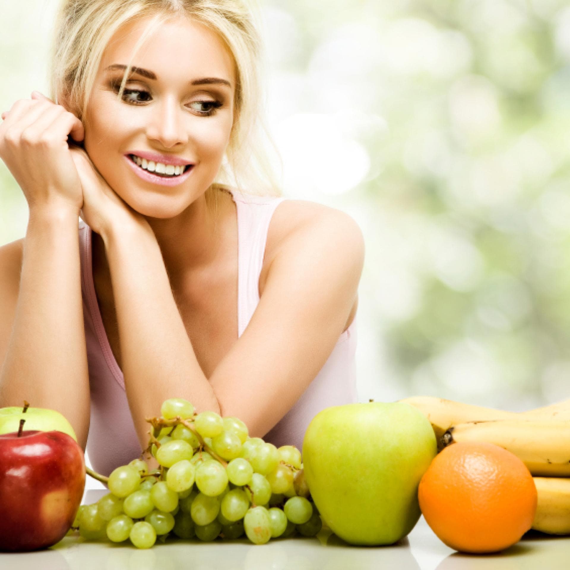 Frau kann sich nicht entscheiden, welches Obst sie essen soll - sie ernährt sich sehr gesund 