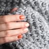 Frauenhand hält Wollpulli