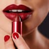 Junge Frau trägt roten Lippenstift auf