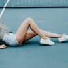 Frau mit nackten Beinen auf Tennisplatz