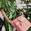 Frau überreicht ein Weihnachtsgeschenk.