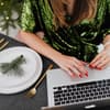 Frau arbeitet in weihnachtlicher Atmosphäre am Laptop.