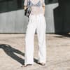 Frau trägt weiße Jeans im Streetstyle