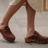Frau trägt braune Clogs im Streetstyle