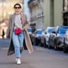 Frau im Winterlook mit Mantel und Sneakers