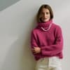 Frau im pinken Statement-Rollkragenpullover