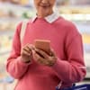 Frau guckt auf Angebote der Supermärkte in der App