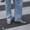 Frau trägt Party-Flats zu einer Jeans mit weitem Bein.
