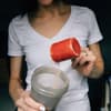 Frau macht sich Proteinshake für mehr Eiweiß