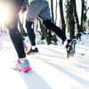 Zwei Personen joggen im Winter.