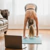 Frau macht Online Fitnesskurse auf einer Sportmatte
