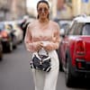 Frau im eleganten Streetstyle mit einer Bluse in der Farbe Peach Fuzz.