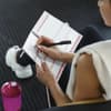 Frau schreibt sich einen Trainingsplan Ganzkörper