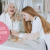 Zwei Frauen lachen zusammen.
