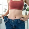 Frau trägt Hose, die zu groß am Bauch ist