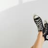 Frau trägt Chucks an den Füßen