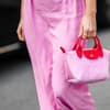 Frau trägt pinke Longchamp-Tasche im Streetstyle