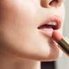 Frau trägt selbst gemachten Lippenstift auf Frau trägt selbst gemachten Lippenstift auf